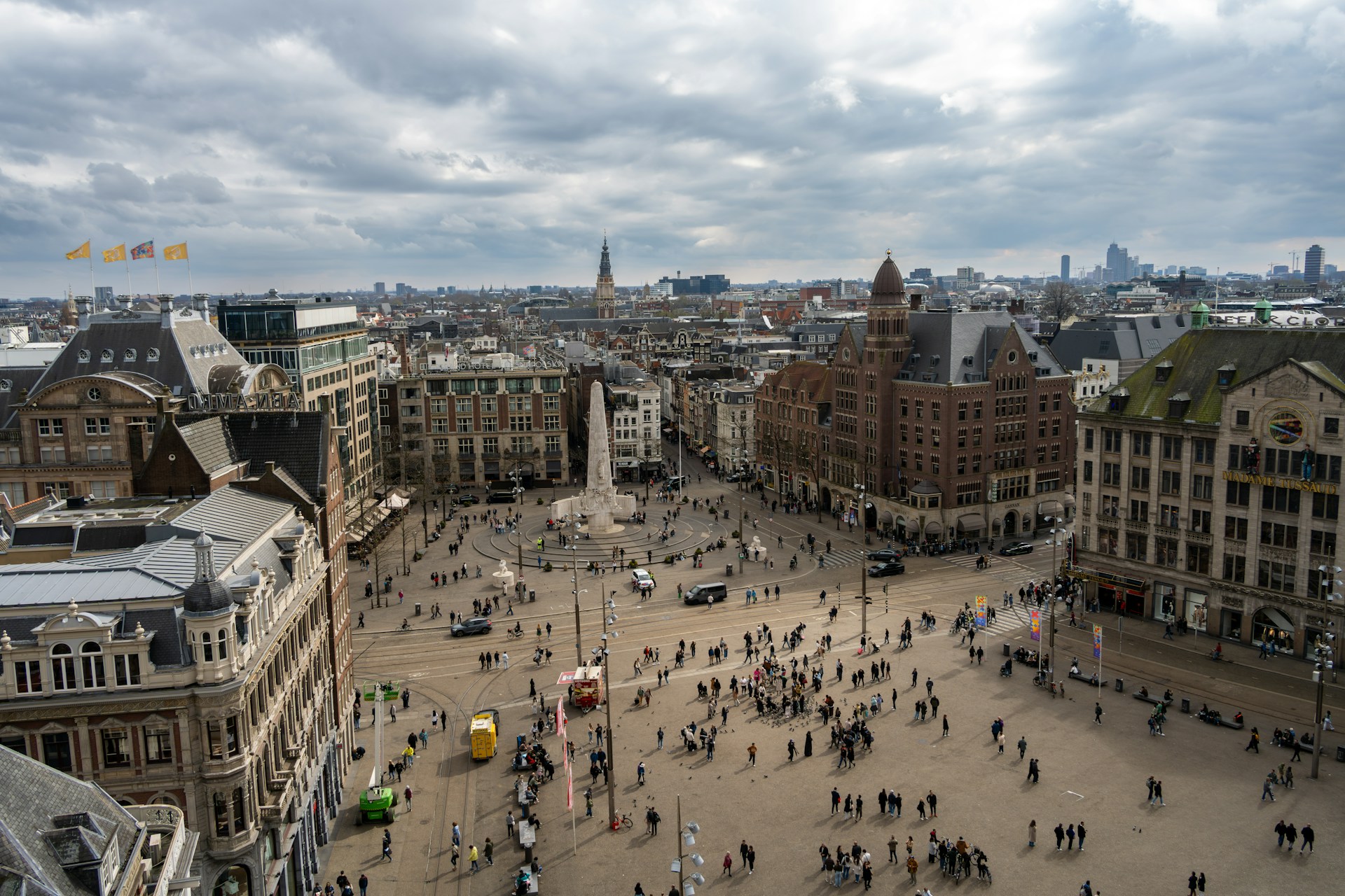 Aerial view of Dam Square in Amsterdam with the National Monument and people walking in the square.